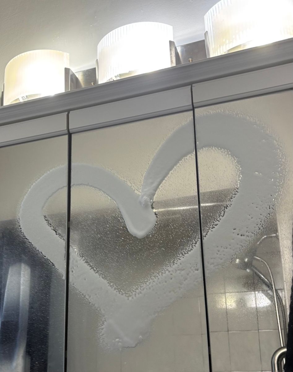A heart drawn on a freshly cleaned glass shower door